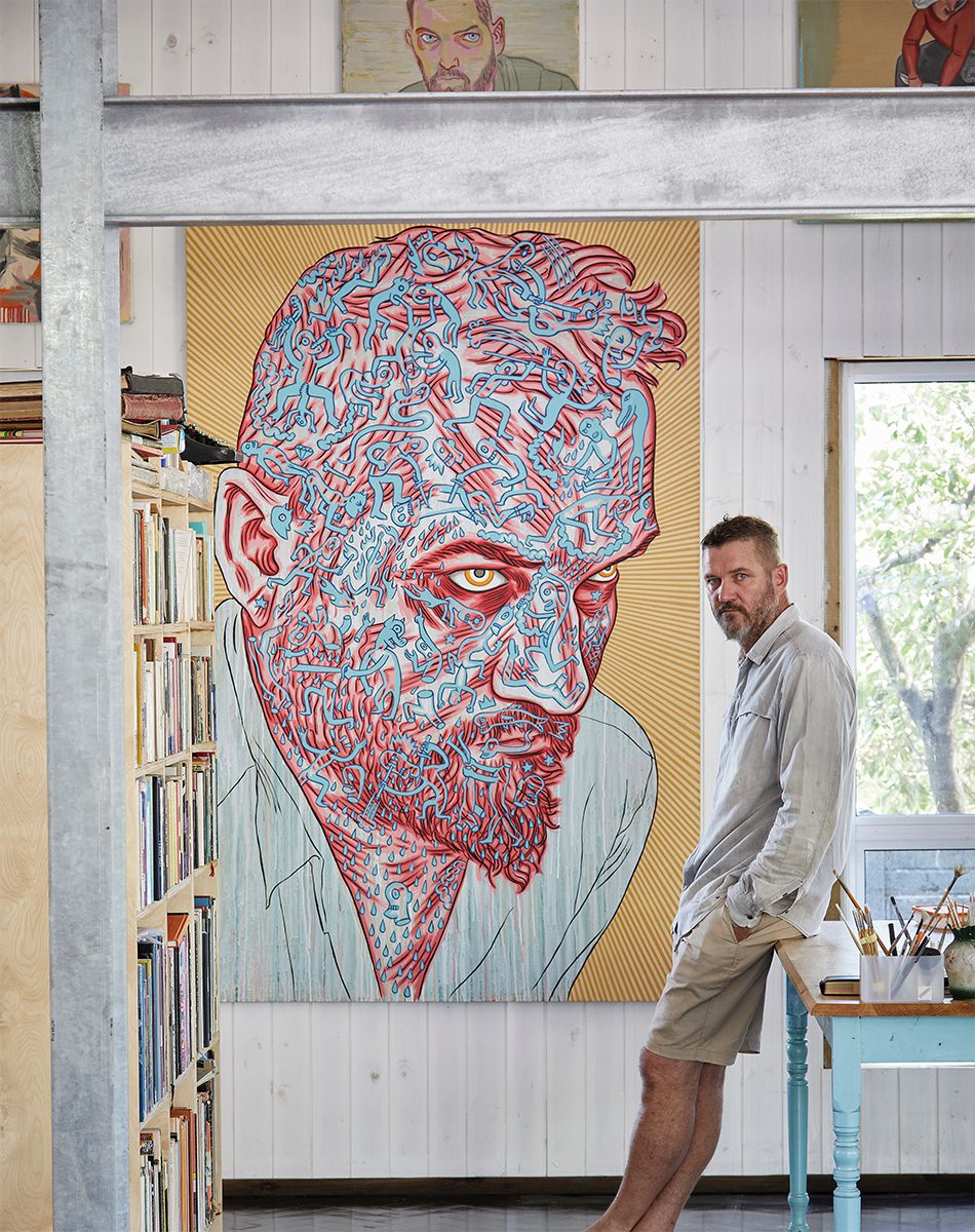 Conrad Botes in front of a dramatic piece from his The Temptation to Exist series